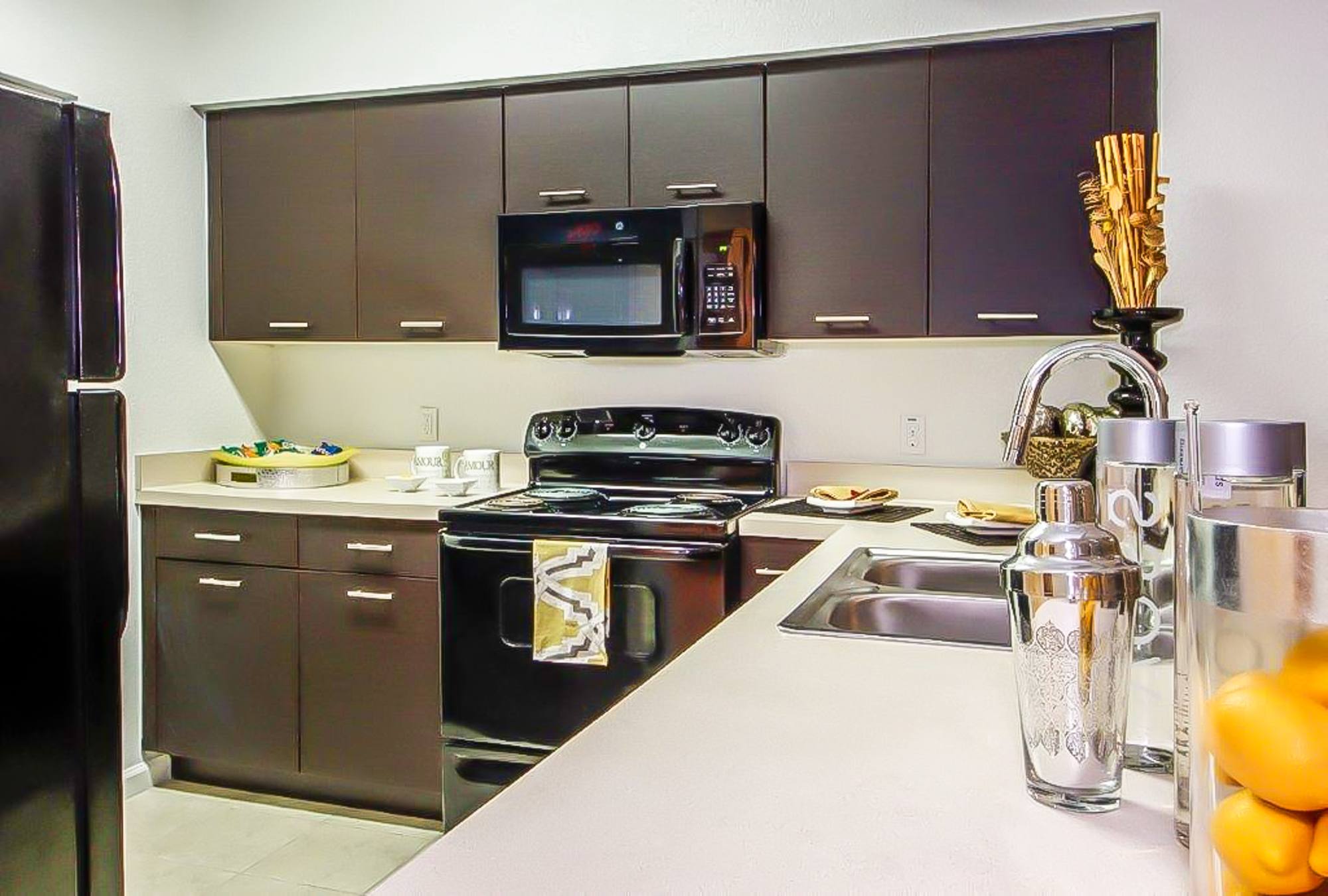 A kitchen with a black stove top oven and a black microwave.